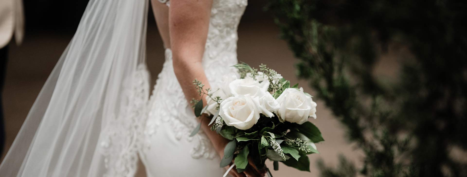 Bride walking with bouquet of flowers.