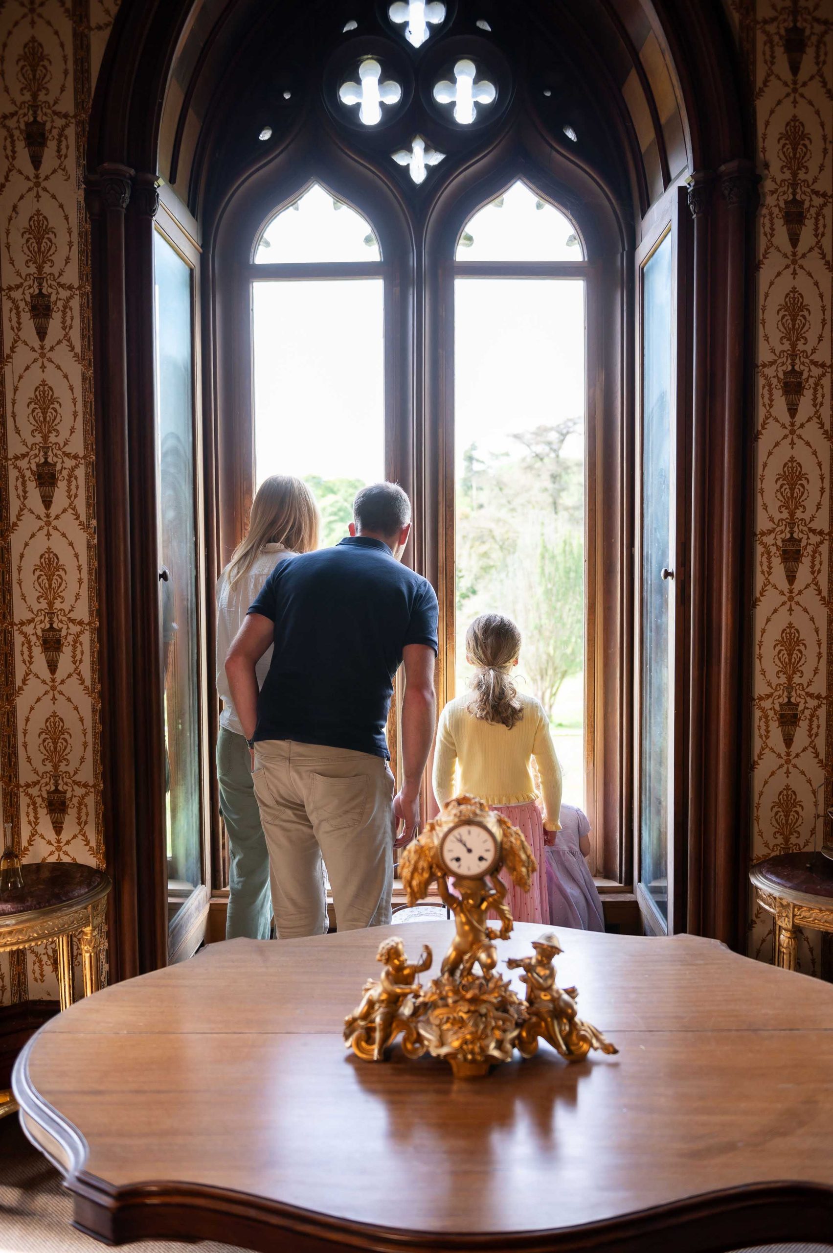 Family drawing room at Johnstown Castle featuring elegant decor and tall arched window with natural light.