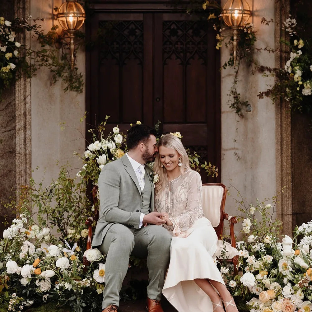 Bride and groom seated with flowers