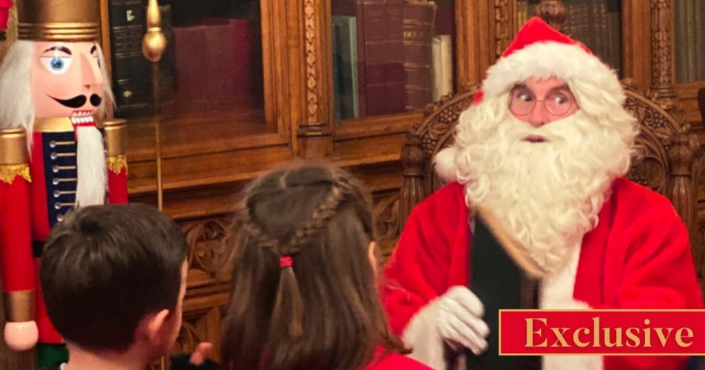 Santa Claus sitting in a decorated room with children gathered in front of him, next to a large wooden nutcracker figure. A red banner in the corner reads Exclusive.