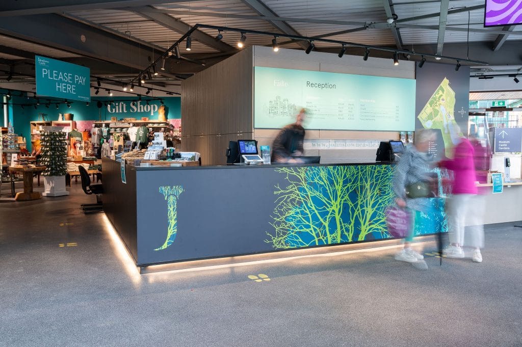 Entrance desk to Johnstown Castle with a person at the desk and a staff member behind