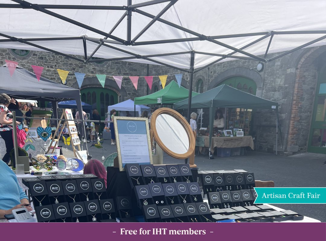 Craft stalls at Johnstown Castle decorated with colourful bunting during a summer 2025 event, with people browsing handmade goods in the courtyard of the Irish Agricultural Museum.